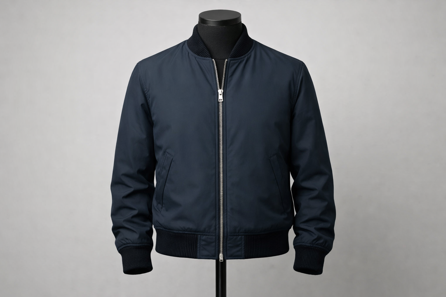 Men's bomber jacket on a mannequin showing ribbed collar, cuffs, hem, and front zipper